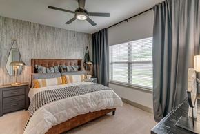 Fort Worth apartment for rent - A bedroom with a large bed and a ceiling fan.
