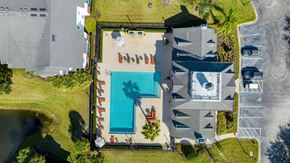 Ormond Beach apartment for rent - arial view of a house with a swimming pool and a yard with a beach