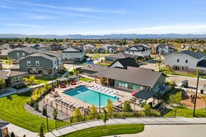 Brighton townhouse for rent - A large swimming pool surrounded by a black fence and a grassy area with a few trees.