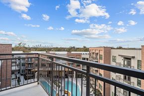 Austin apartment for rent - A balcony with a pool and buildings in the distance.