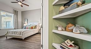 Austin apartment for rent - A bedroom with a bed and a shelf with decorative items.