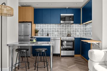 Oakland apartment for rent - A modern kitchen with blue cabinets and a white island.