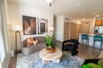Georgetown apartment for rent - A living room with a grey couch, a wooden coffee table, and a painting on the wall.