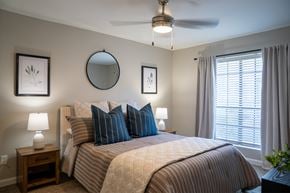 Houston apartment for rent - A bedroom with a large bed and a ceiling fan.