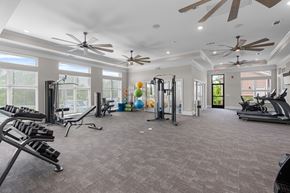 Lebanon apartment for rent - A spacious gym with various exercise equipment and a ceiling fan.
