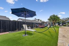 San Antonio apartment for rent - A blue umbrella is on a lawn.