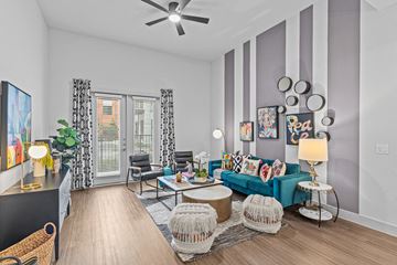 Austin apartment for rent - A living room with a blue couch and a ceiling fan.