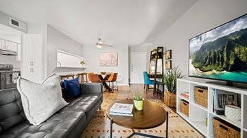 Round Rock apartment for rent - A living room with a grey couch and a television on the wall.