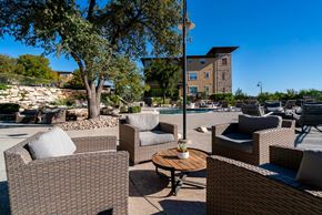 Austin apartment for rent - a patio with chairs and a table near a swimming pool