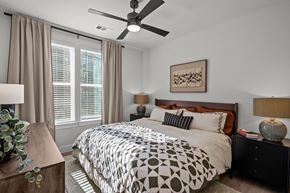 Austin apartment for rent - A bedroom with a bed, nightstand, and a ceiling fan.