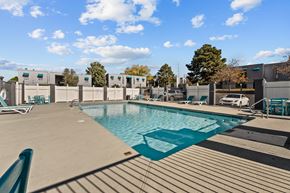 Albuquerque apartment for rent - a swimming pool at an apartment complex with chairs and a privacy fence