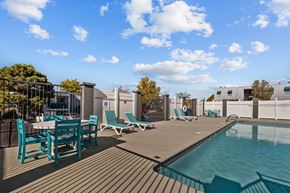 Albuquerque apartment for rent - a pool and patio with chairs and tables on a rooftop