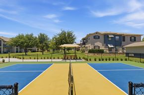 Arlington apartment for rent - A playground with a blue and yellow surface and a black fence.