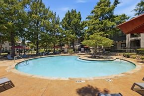 Arlington apartment for rent - A small pool surrounded by trees and a building.