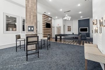 Carrollton apartment for rent - A living room with a grey carpet and a black couch.