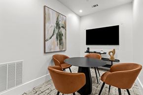 San Antonio apartment for rent - A modern dining room with a large painting on the wall and a flat screen TV mounted above the table.