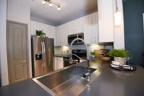 Richmond apartment for rent - A modern kitchen with a stainless steel sink and refrigerator.