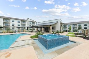 Hutto apartment for rent - A swimming pool in front of apartment buildings.