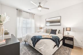 Hutto apartment for rent - A bedroom with a large bed and a ceiling fan.