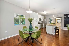 Kissimmee apartment for rent - a dining area with a glass table and chairs and a kitchen in the background