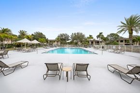 Port Saint Lucie apartment for rent - a swimming pool with lounge chairs and tables