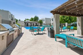 Albuquerque apartment for rent - A sunny day at the outdoor pool area with blue chairs and tables.