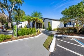 Orlando apartment for rent - a white building with palm trees and a sidewalk in front of it