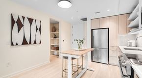 Atlanta apartment for rent - A modern kitchen with a wooden table and stainless steel appliances.