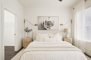 Nashville apartment for rent - A bedroom with a large bed, a painting above it, and two lamps on either side of the bed.