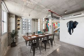 Miami apartment for rent - a dining room with a long wooden table and black chairs