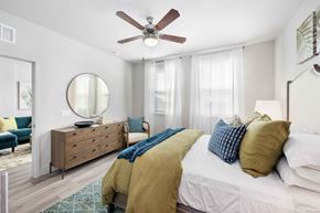 Davenport apartment for rent - A bedroom with a white bed and a blue chair.