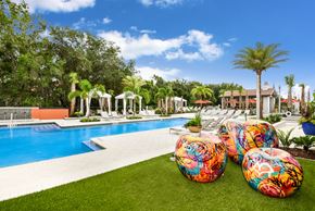 Orlando apartment for rent - A pool surrounded by palm trees and a white gazebo.