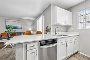 Las Vegas apartment for rent - A modern kitchen with white cabinets and a stainless steel dishwasher.