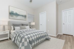 Euless apartment for rent - A bedroom with a large bed and a painting on the wall.