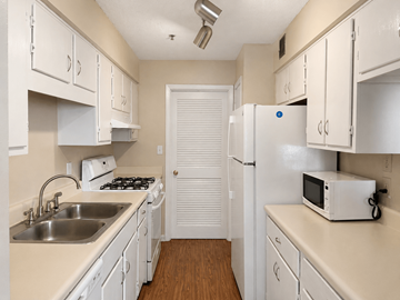 Atlanta apartment for rent - A small kitchen with white cabinets and appliances.