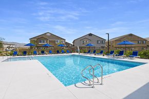 North Las Vegas apartment for rent - A large swimming pool with a diving board and lounge chairs.