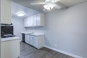 Sacramento apartment for rent - A kitchen with white cabinets and a black fridge.