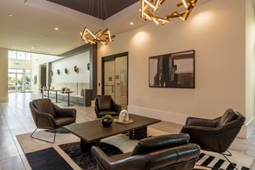 Grand Prairie apartment for rent - A modern living room with black leather chairs and a wooden coffee table.