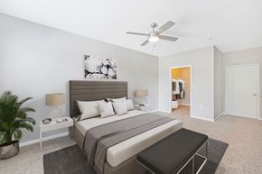 Houston apartment for rent - a bedroom with a bed and a ceiling fan