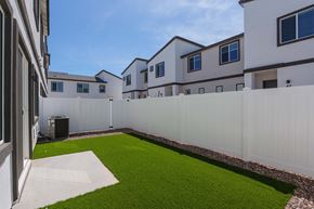 Phoenix apartment for rent - A white fence surrounds a green lawn in front of a building.