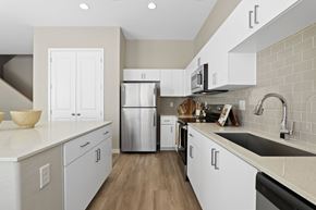 Phoenix apartment for rent - A modern kitchen with white cabinets and a stainless steel refrigerator.