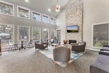 Tyler apartment for rent - A living room with a stone fireplace and a television mounted above it.