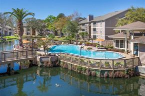 Orange Park apartment for rent - a swimming pool with a wooden deck next to a body of water