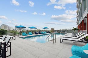 Miami apartment for rent - the pool on the rooftop of a building with blue umbrellas