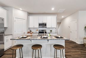 Concord townhouse for rent - A kitchen with white cabinets and a granite countertop.