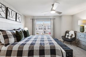 Concord townhouse for rent - A bedroom with a large bed and a chair by the window.