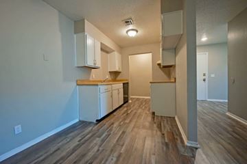 Oklahoma City apartment for rent - A kitchen with white cabinets and a wooden floor.