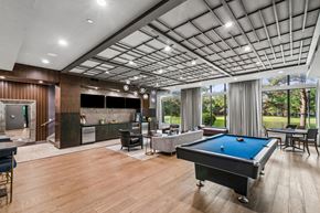 Katy apartment for rent - A billiards table is in the middle of a room with a pool table and a bar.