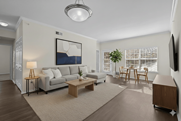 Killeen apartment for rent - A living room with a grey couch, a coffee table, a lamp, a painting, a dining table with chairs, and a flat-screen TV mounted on the wall.