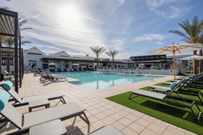Mesa apartment for rent - A sunny day at the poolside with lounge chairs and umbrellas.